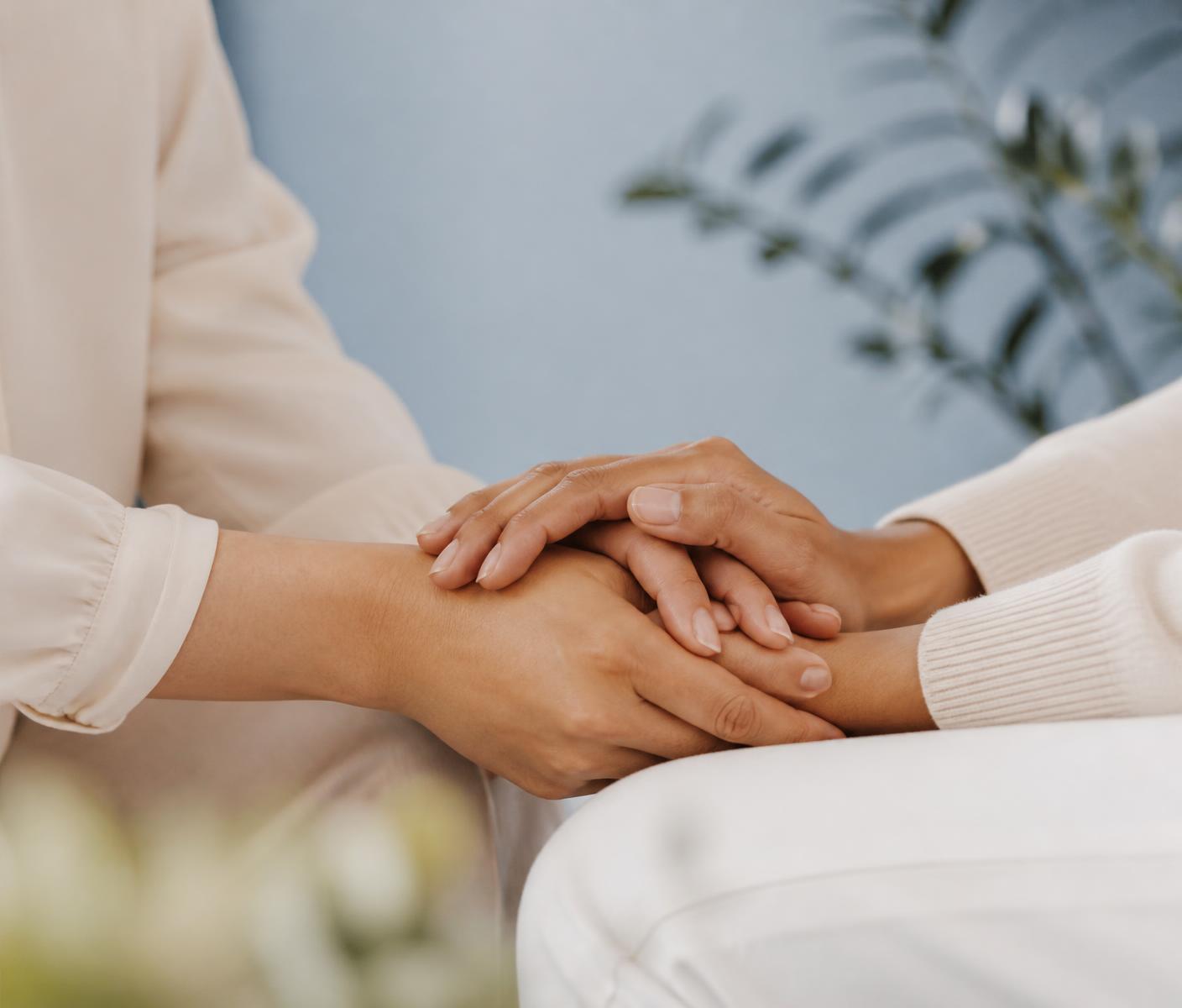 Clinician holding a patient's hands in a moment of unhurried care